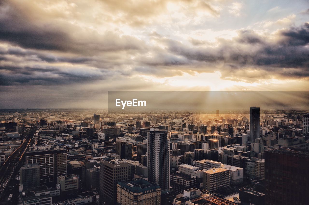 Aerial view of city against cloudy sky