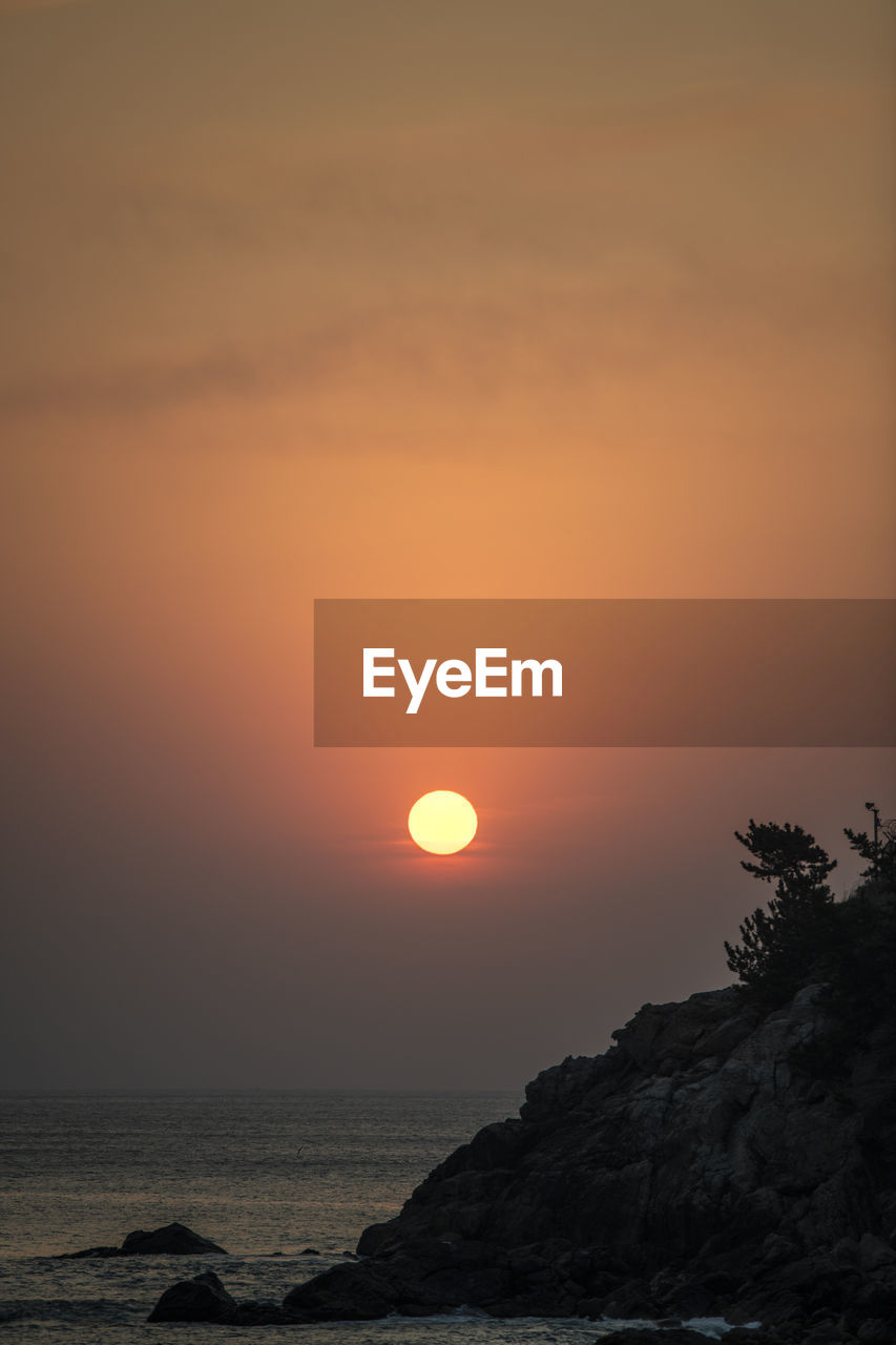 SCENIC VIEW OF SEA AGAINST SKY AT SUNSET