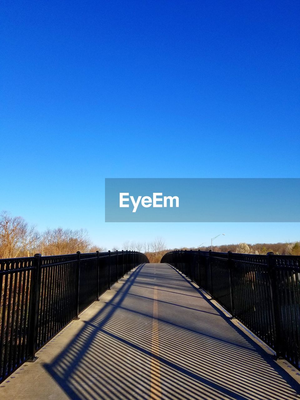 sky, clear sky, the way forward, blue, nature, sunlight, no people, diminishing perspective, copy space, railing, architecture, day, horizon, sunny, built structure, outdoors, vanishing point, reflection, morning, fence, bridge, tranquility, transportation, scenics - nature, environment, footpath, landscape, tranquil scene