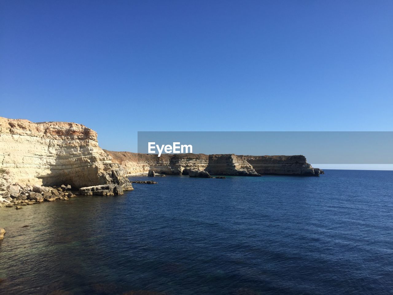 Scenic view of sea against clear blue sky