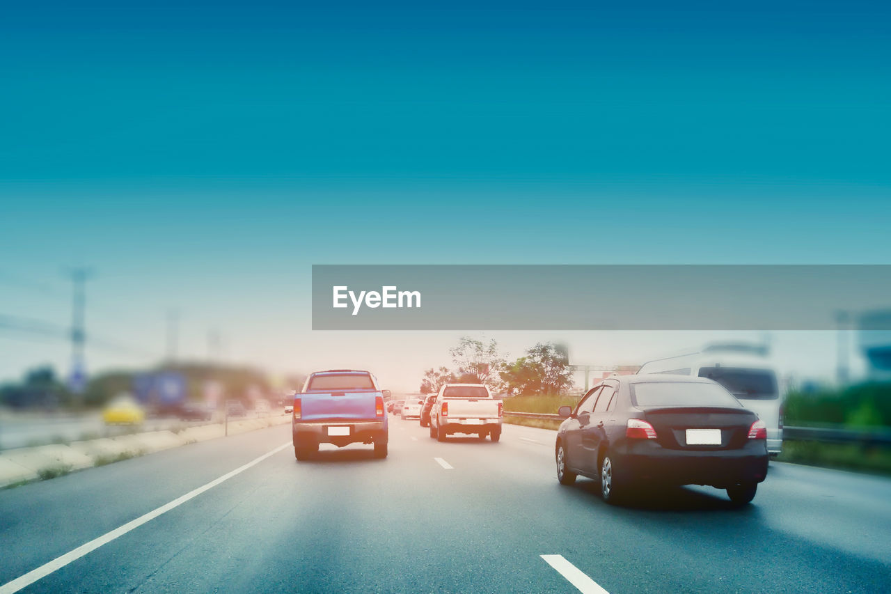 CARS ON ROAD AGAINST SKY