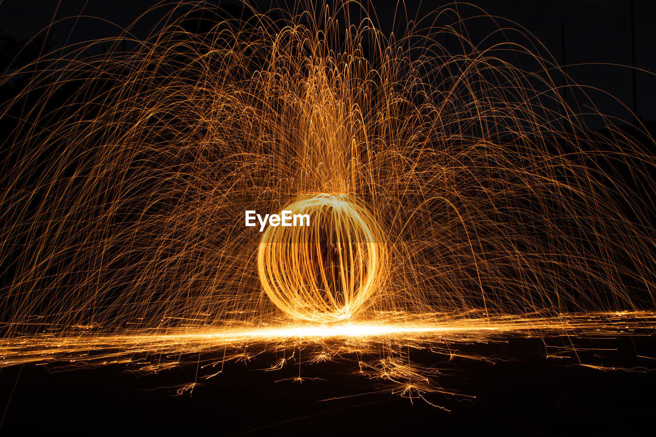 Illuminated wire wool spinning at night