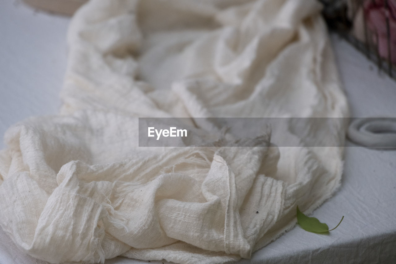 HIGH ANGLE VIEW OF WHITE FABRIC ON TABLE AT HOME