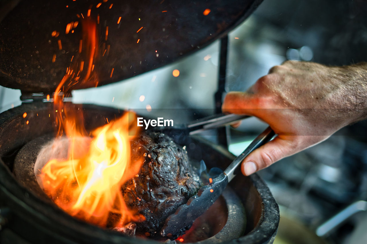 Midsection of person preparing cabbage in burning fire