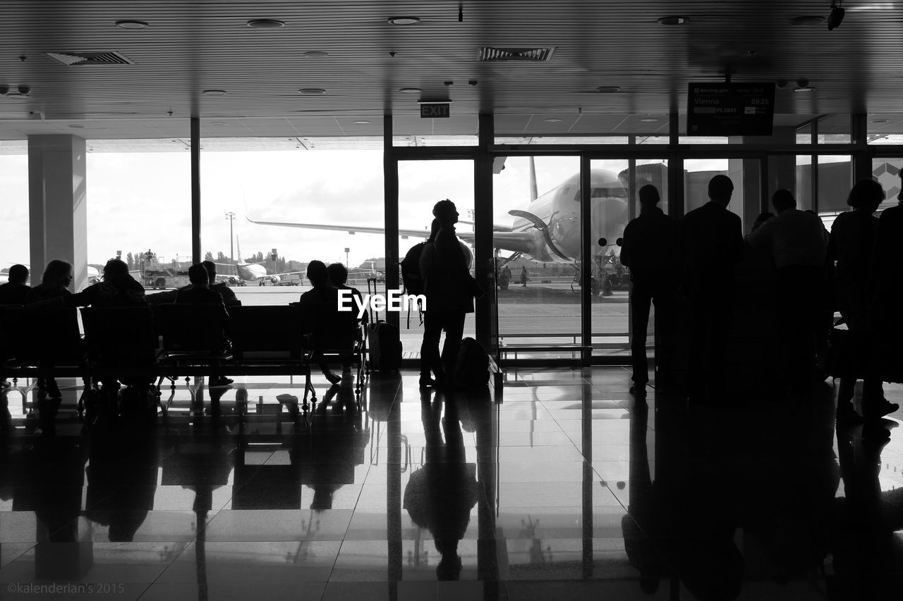 SILHOUETTE PEOPLE STANDING BY AIRPORT