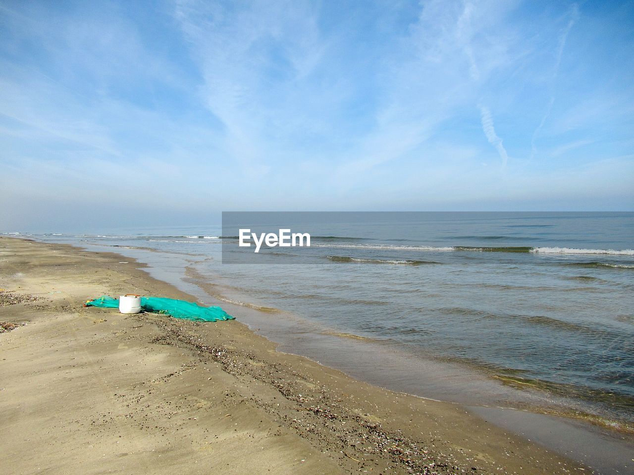 DECK CHAIRS ON BEACH AGAINST SKY