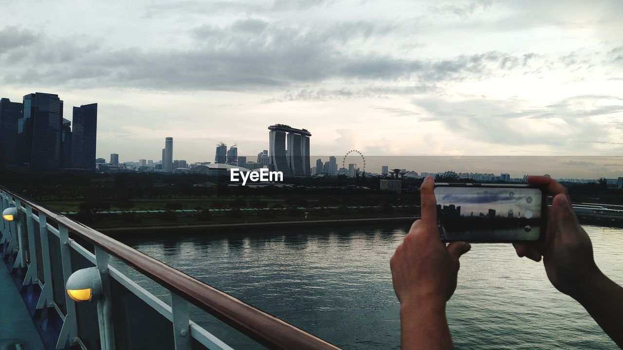 Low angle view of mobile phone in city against sky