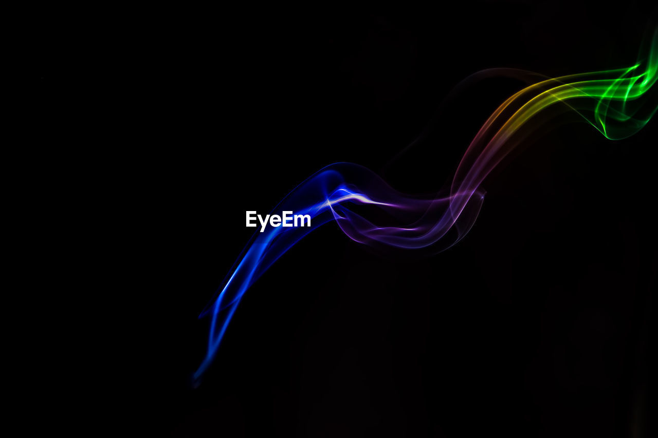 Close-up of multi colored smoke against black background