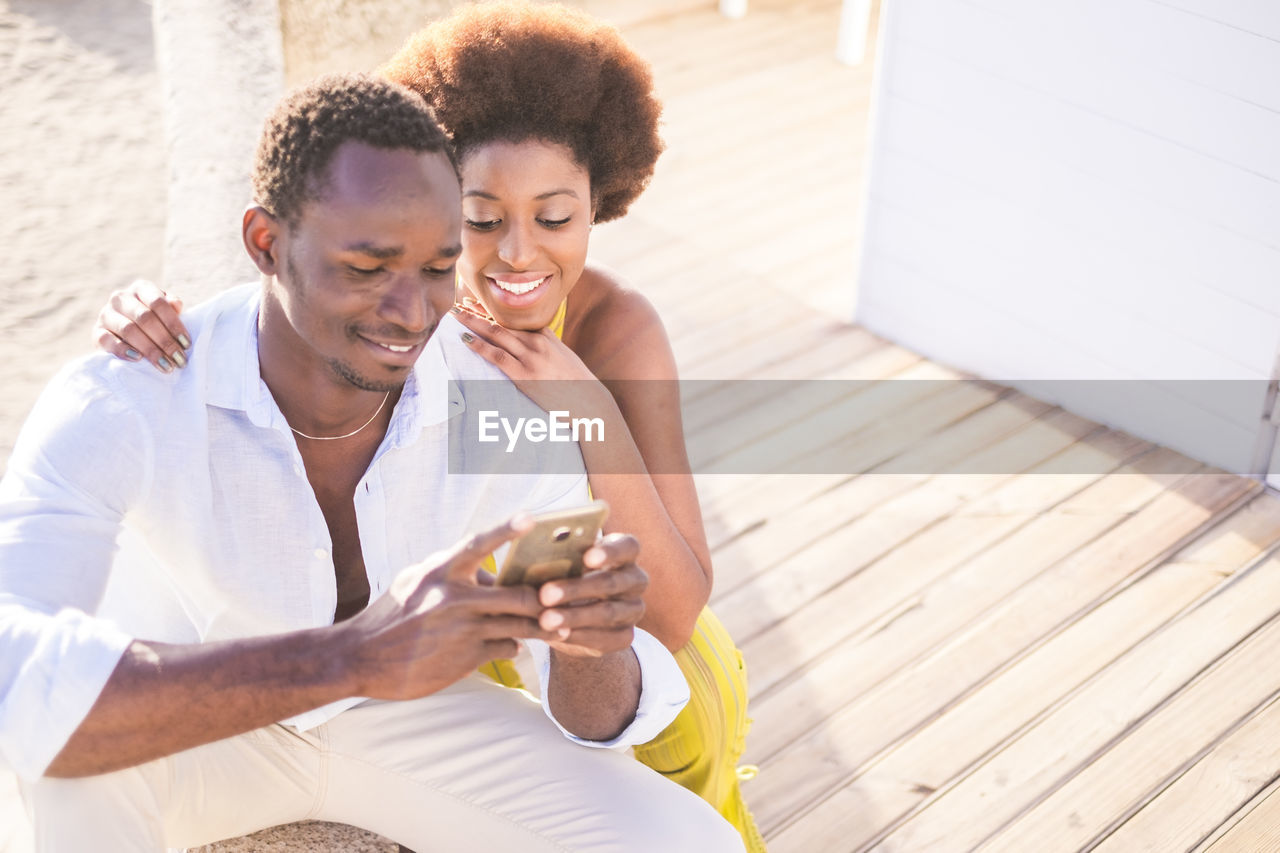 Young man with woman using phone