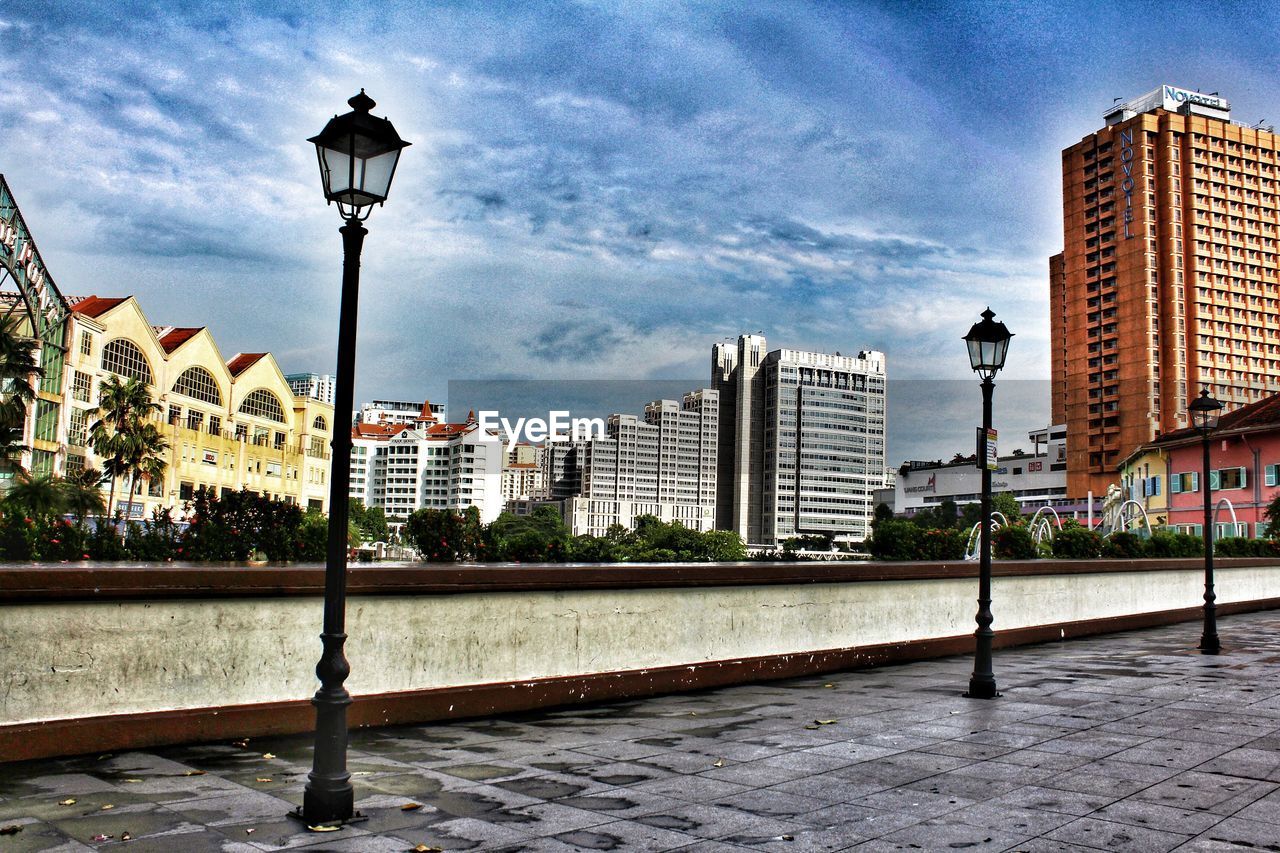 STREET BY BUILDINGS AGAINST SKY