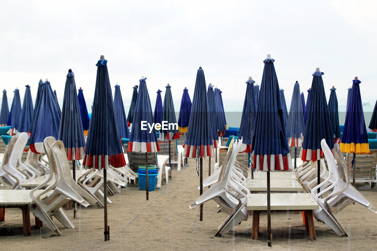 Chairs on beach against sky