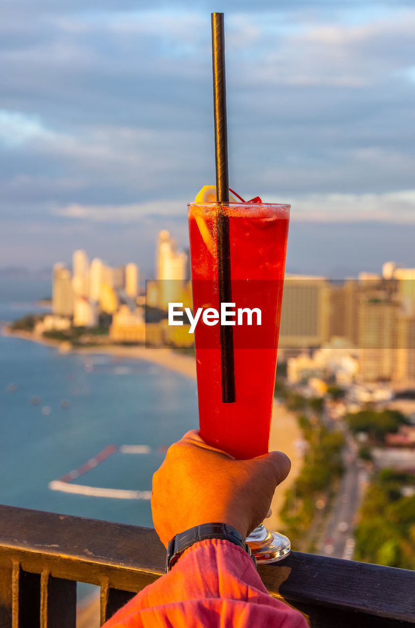 CLOSE-UP OF RED WINE GLASS AGAINST BUILDING