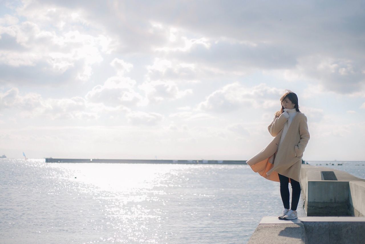 WOMAN STANDING BY SEA