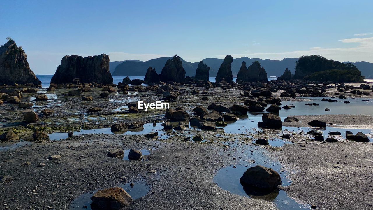 PANORAMIC SHOT OF ROCKS ON BEACH AGAINST SKY