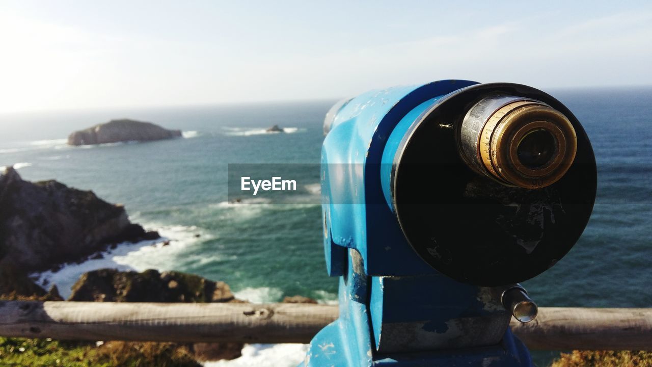 Close-up of coin operated binoculars at observation point against sky