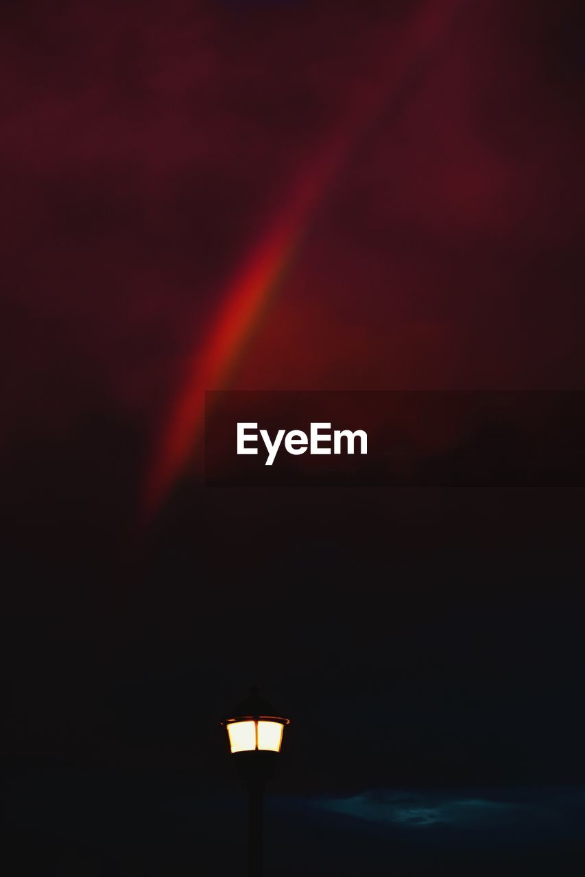 LOW ANGLE VIEW OF RAINBOW OVER STREET LIGHTS