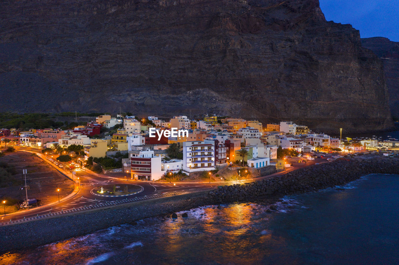 Spain, valle gran rey, drone view of town at edge of la gomera island at dusk