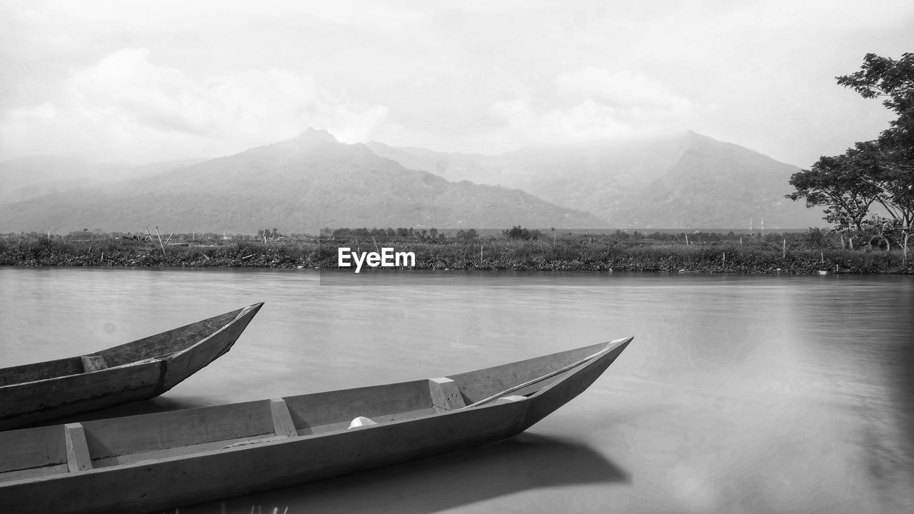 Scenic view of lake by mountains against sky