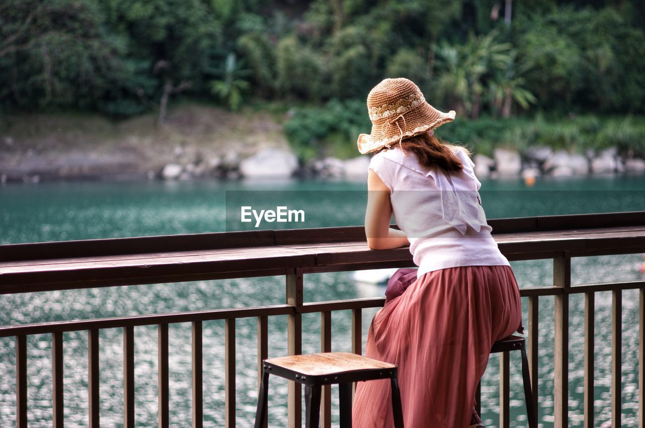 Rear view of woman standing by railing