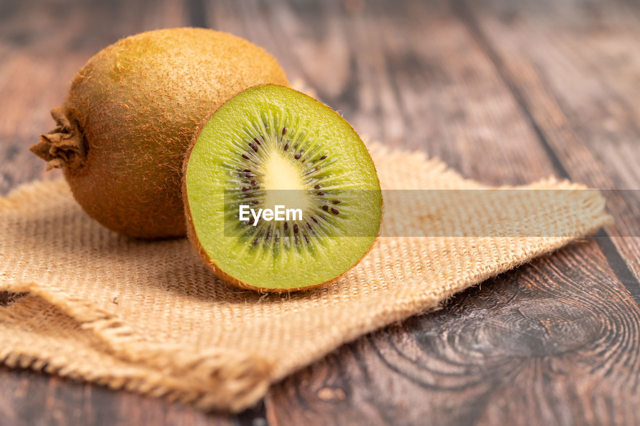 A half of green kiwi on the wooden table