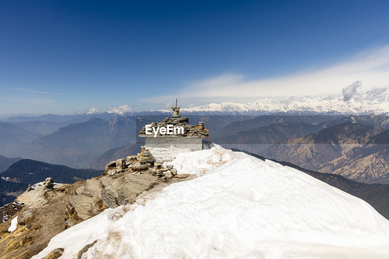 Holy stone at snowcap mountain summit with breathtaking landscape background at morning