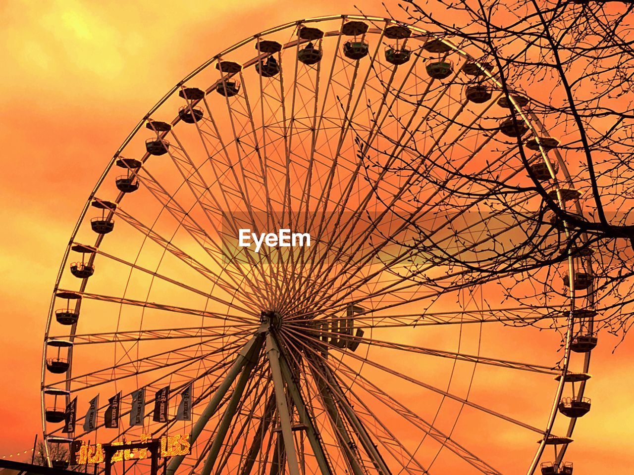 LOW ANGLE VIEW OF FERRIS WHEEL AGAINST SKY AT SUNSET