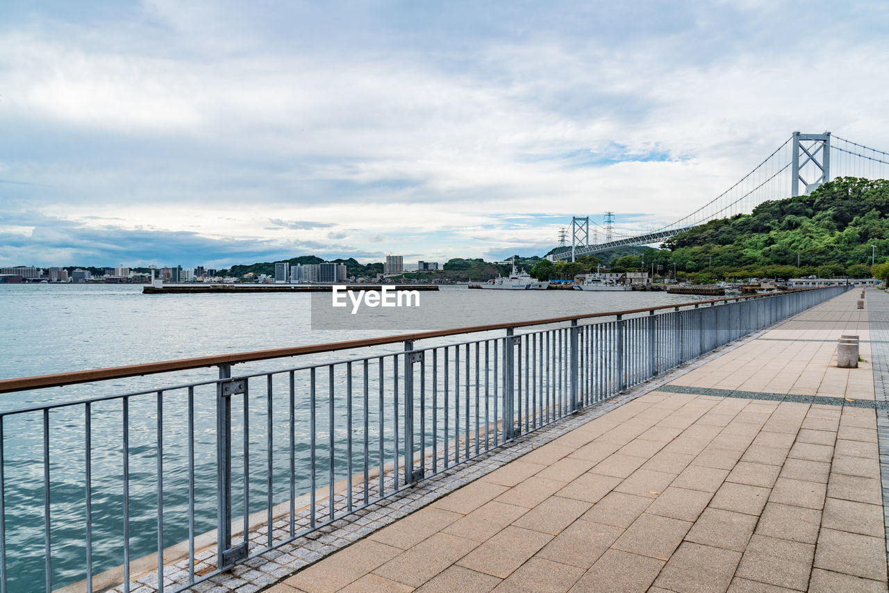 Bridge over sea in city against sky