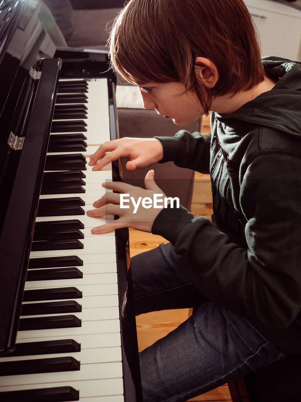 High angle view of boy playing piano at home