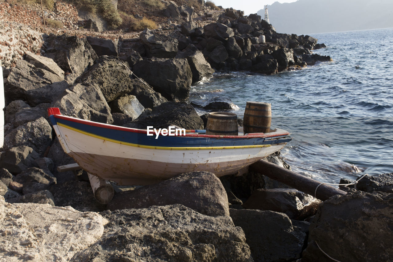 BOAT MOORED ON SHORE BY ROCK FORMATION