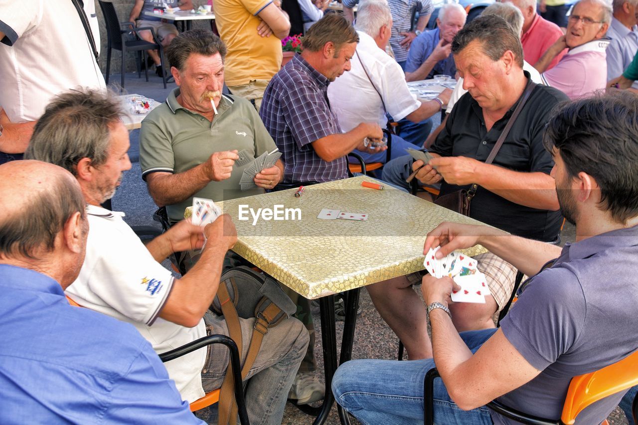 HIGH ANGLE VIEW OF MEN SITTING ON PEOPLE