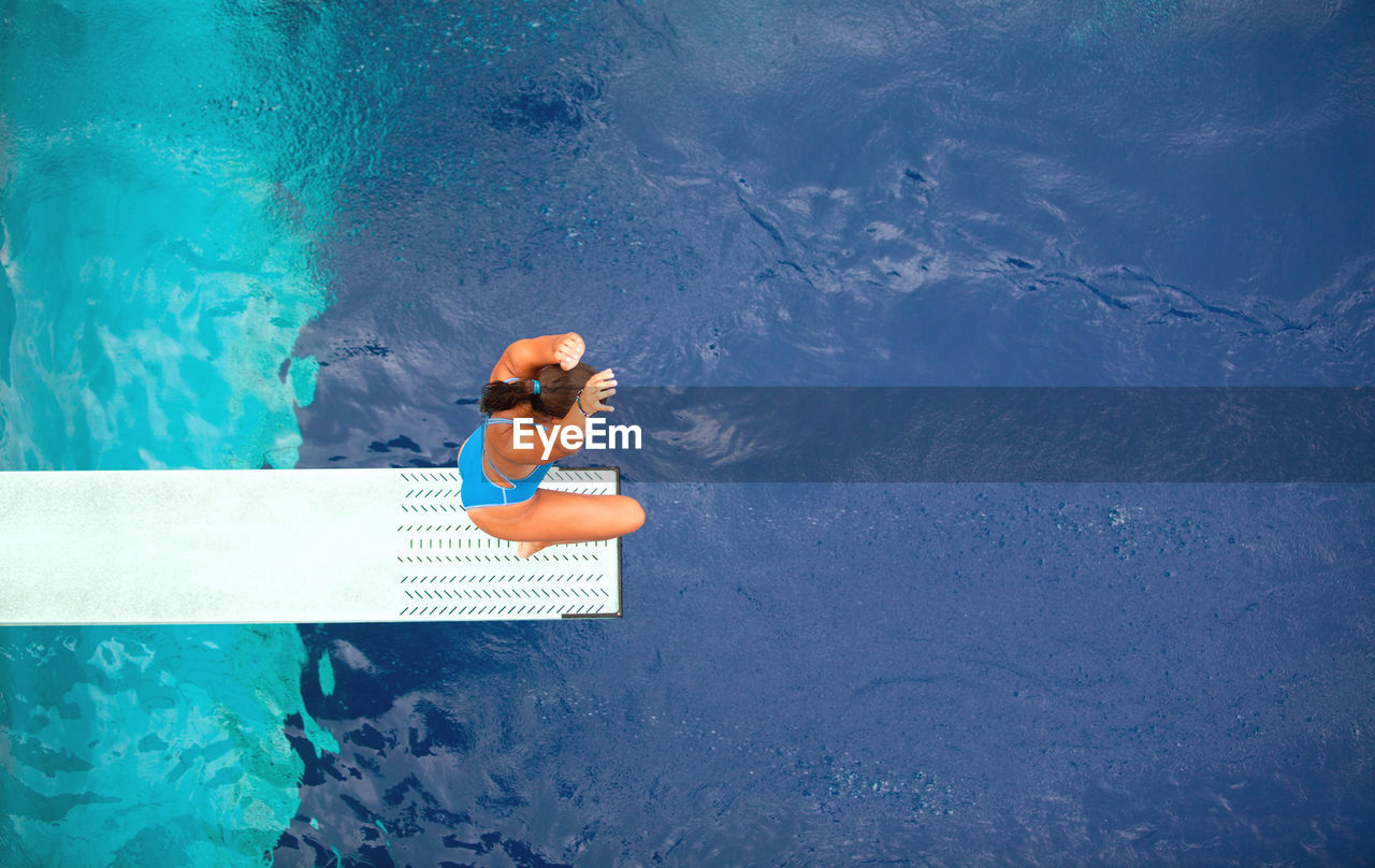 HIGH ANGLE VIEW OF WOMAN IN SWIMMING POOL
