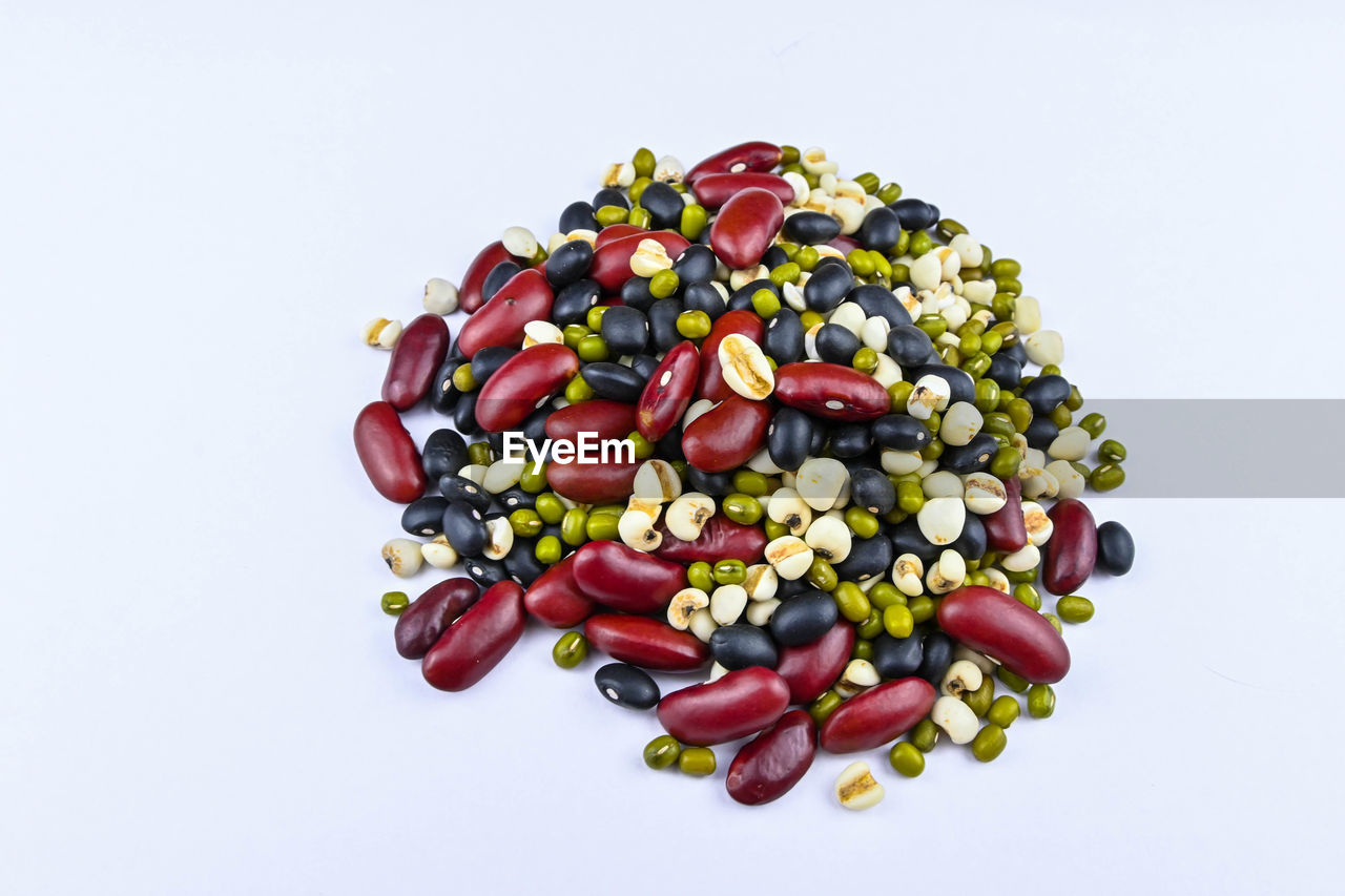 HIGH ANGLE VIEW OF MULTI COLORED CANDIES AGAINST WHITE BACKGROUND