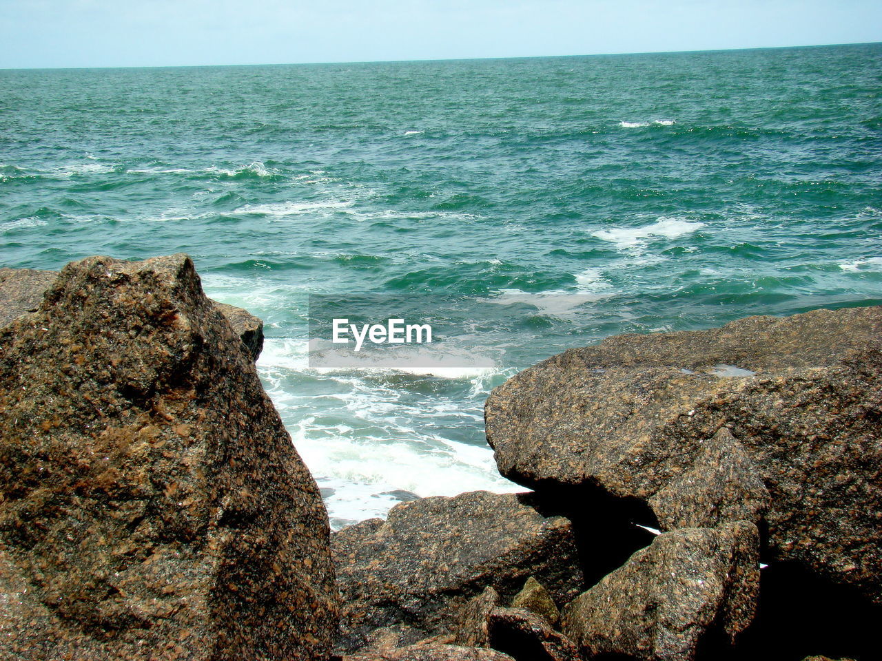 Close-up of rocks at calm blue sea