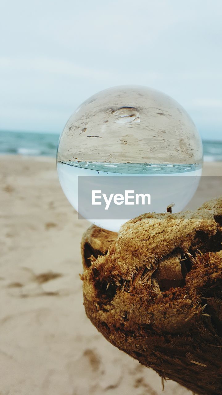 Close-up of crystal ball with beach reflection
