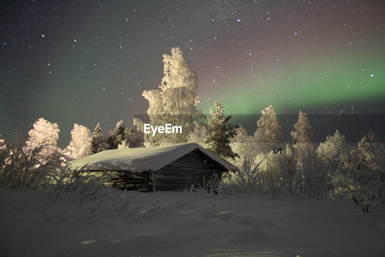 Scenic view of snow covered field against sky at night