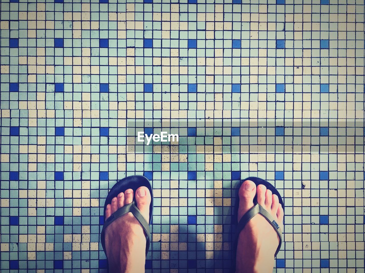 Low section of woman standing on tiled floor