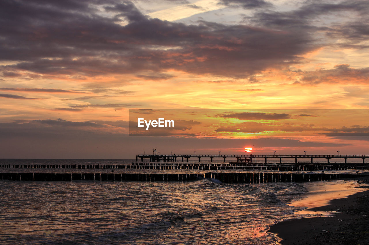 PIER OVER SEA AGAINST CLOUDY SKY