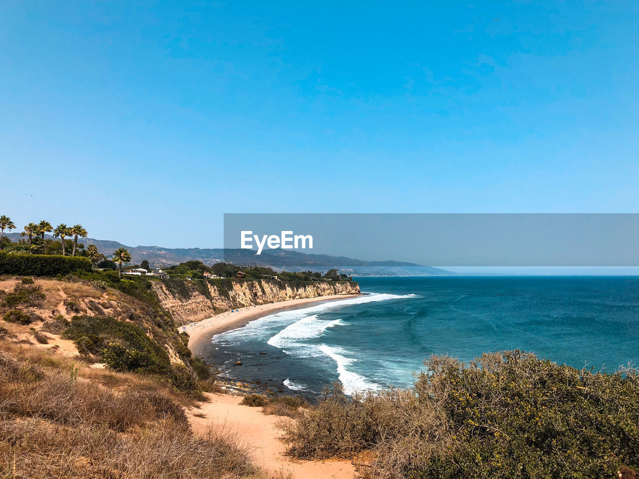 Scenic view of sea against clear blue sky