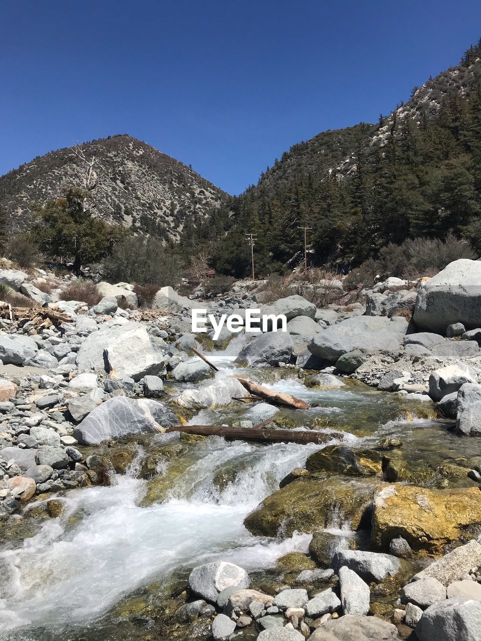 Scenic view of river by mountains against clear sky