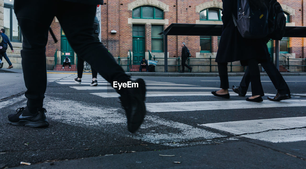 LOW SECTION OF PEOPLE WALKING ON ROAD