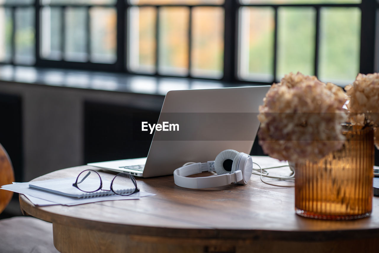 CLOSE-UP OF COFFEE AND LAPTOP ON TABLE AT HOME