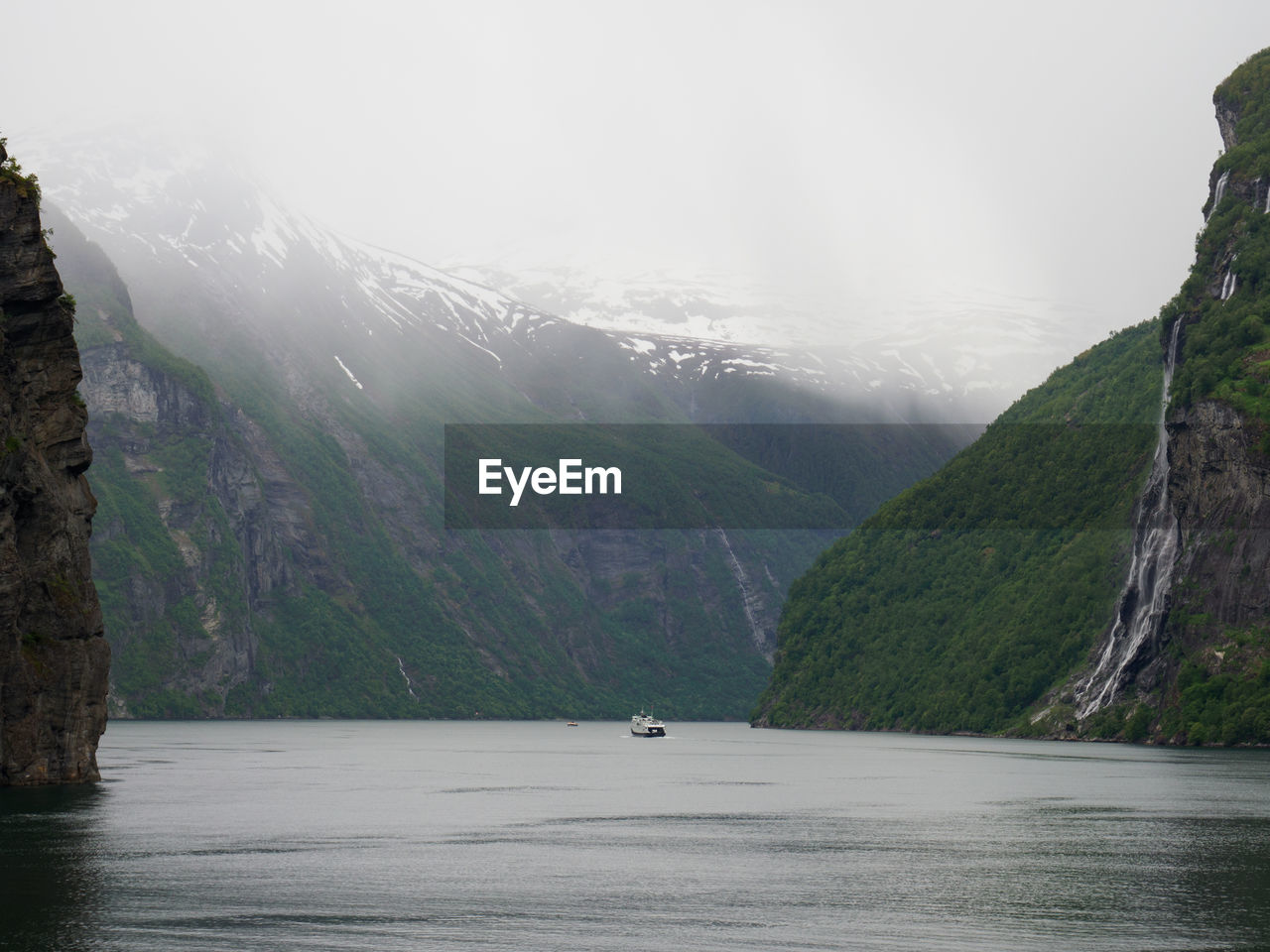 SCENIC VIEW OF MOUNTAINS BY LAKE AGAINST SKY