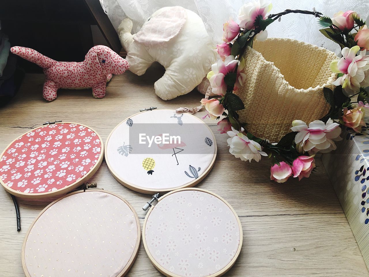 High angle view of embroidery frames by basket and stuffed toys on floor