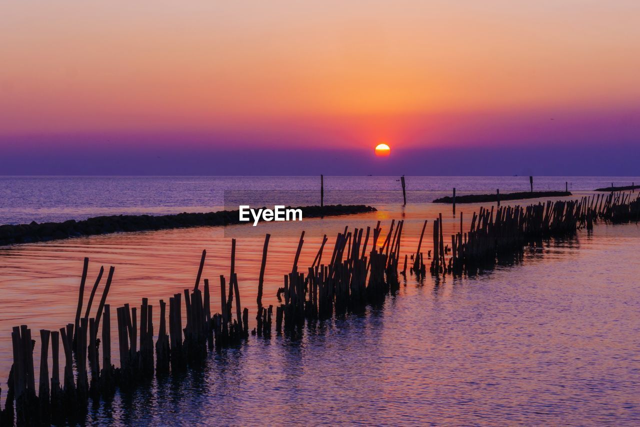 Scenic view of sea against romantic sky at sunset