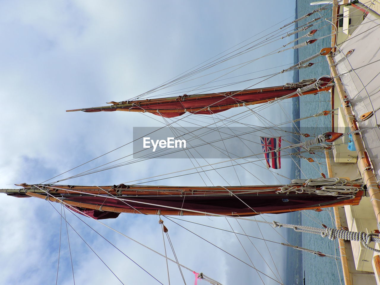 LOW ANGLE VIEW OF SAILBOAT AGAINST SKY AT SEA