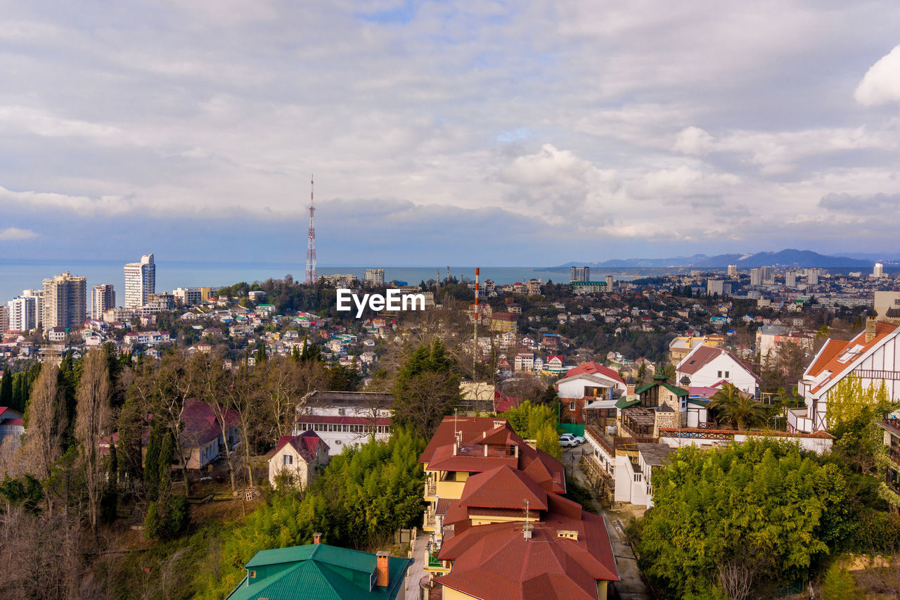 HIGH ANGLE VIEW OF BUILDINGS AGAINST SKY IN CITY