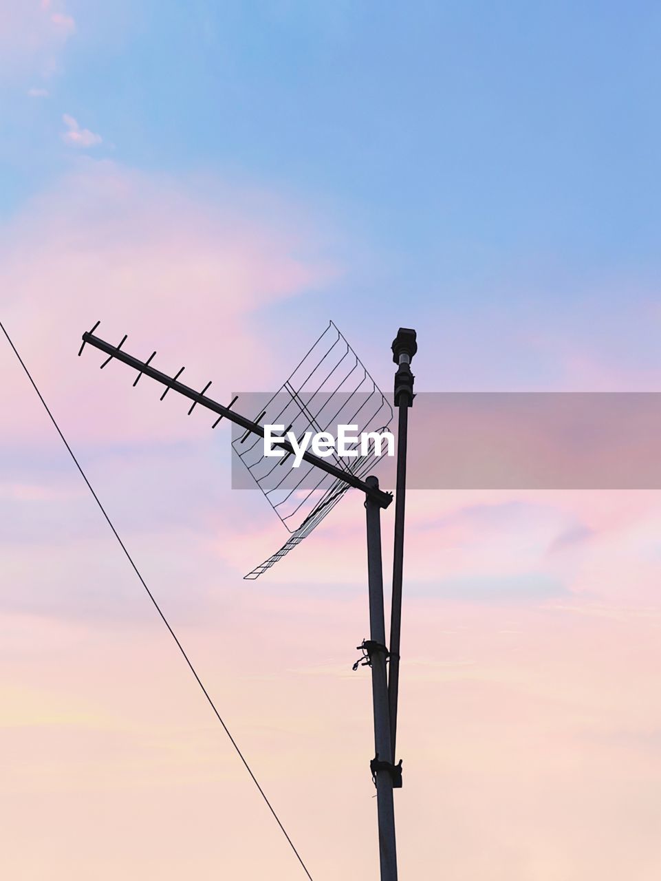 Low angle view of silhouette telephone pole against sky during sunset