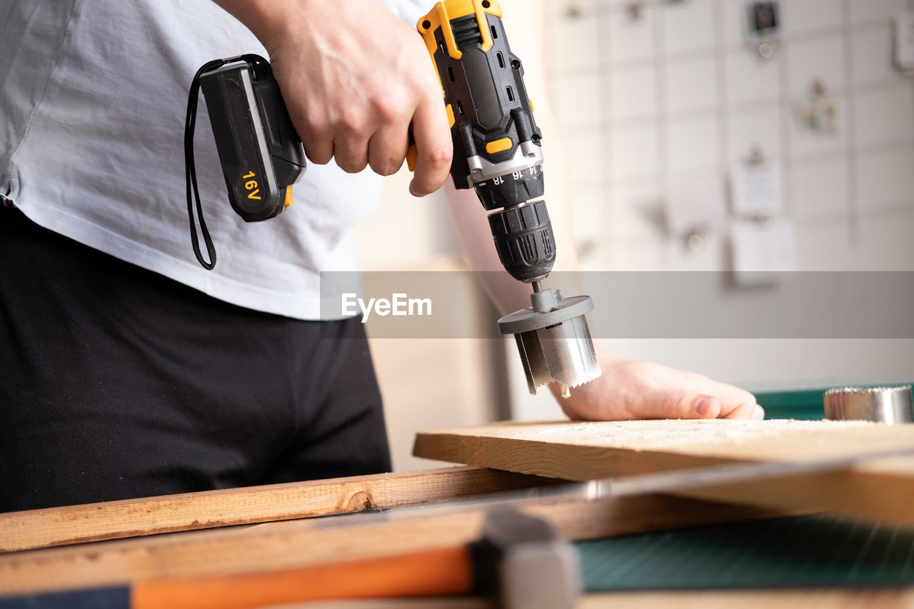 Home workshop. close-up of a man in goggles working with a drill.