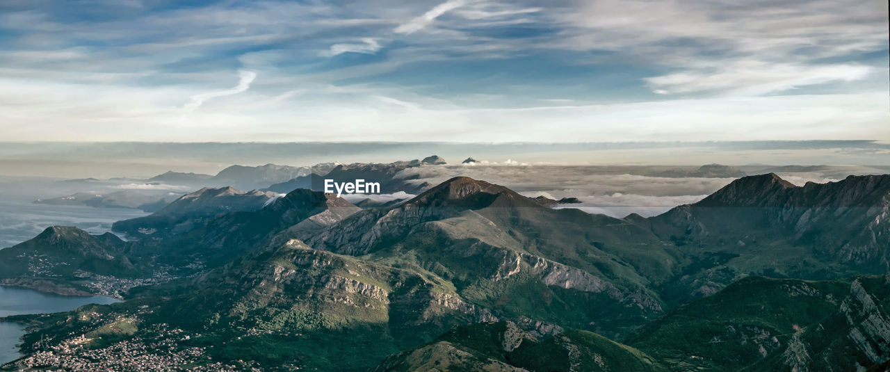 Scenic view of mountain ranges against cloudy sky