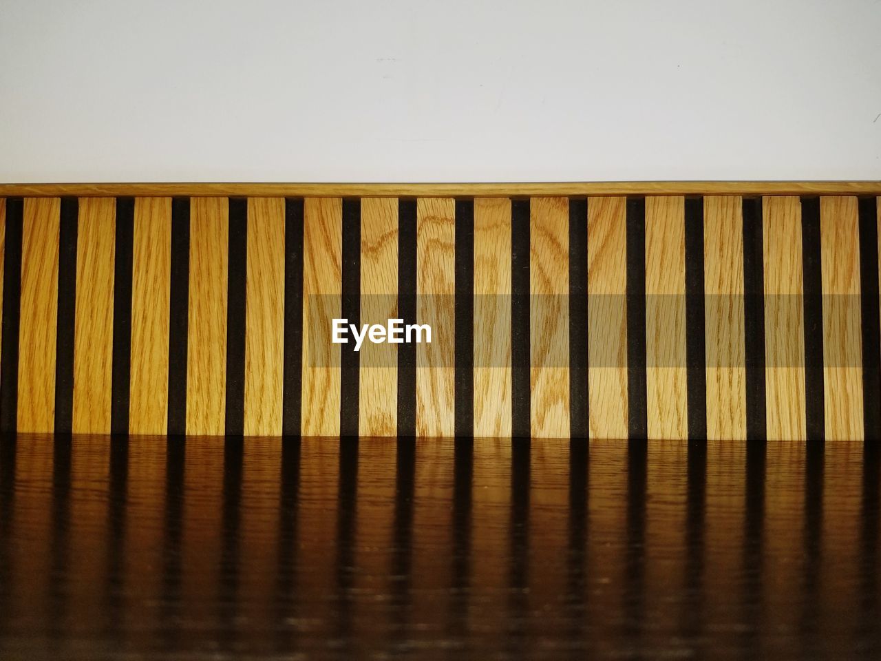 CLOSE-UP OF YELLOW WOODEN TABLE AGAINST WALL